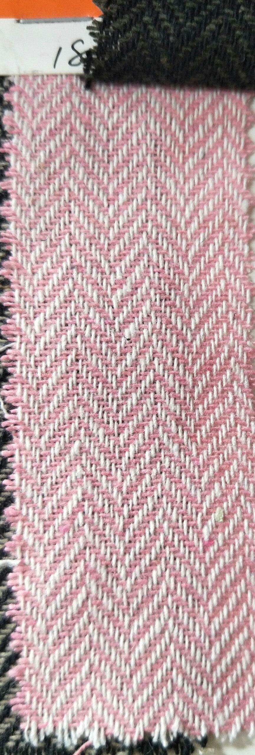 Textile swatch with pink and white herringbone pattern