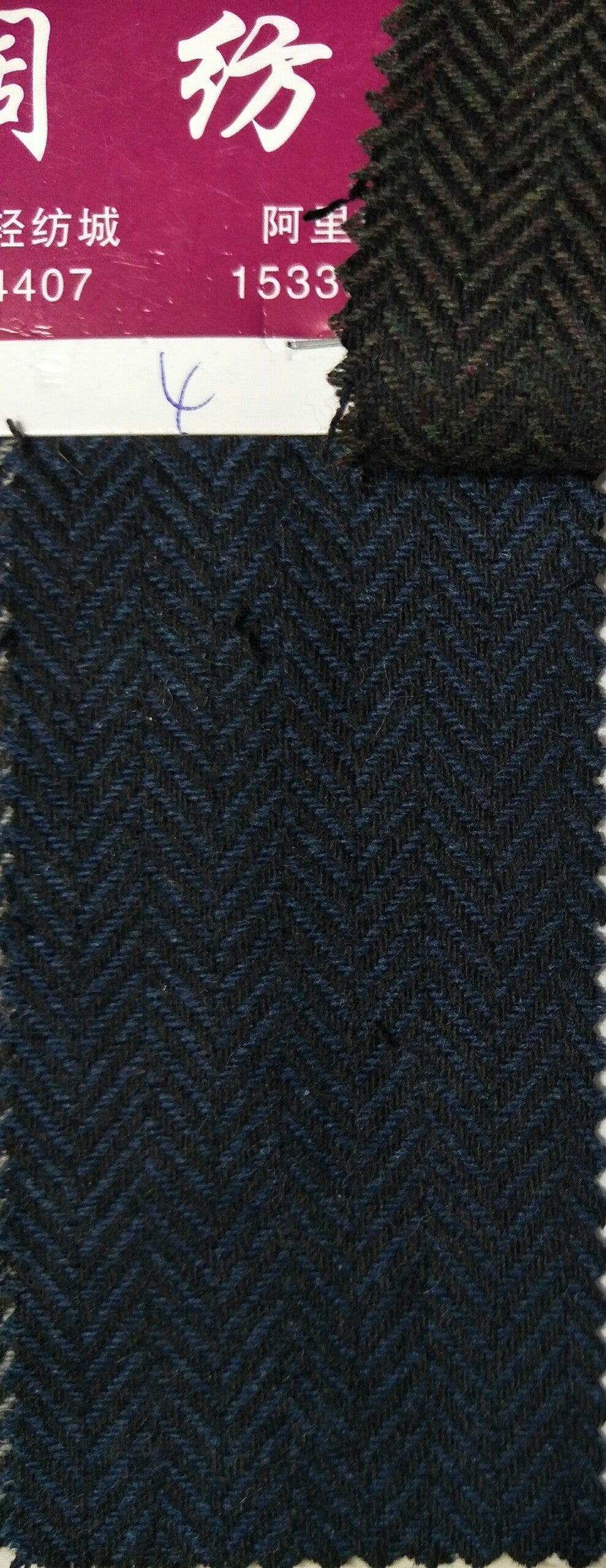 Textured fabric swatch with a herringbone pattern and visible brand name.