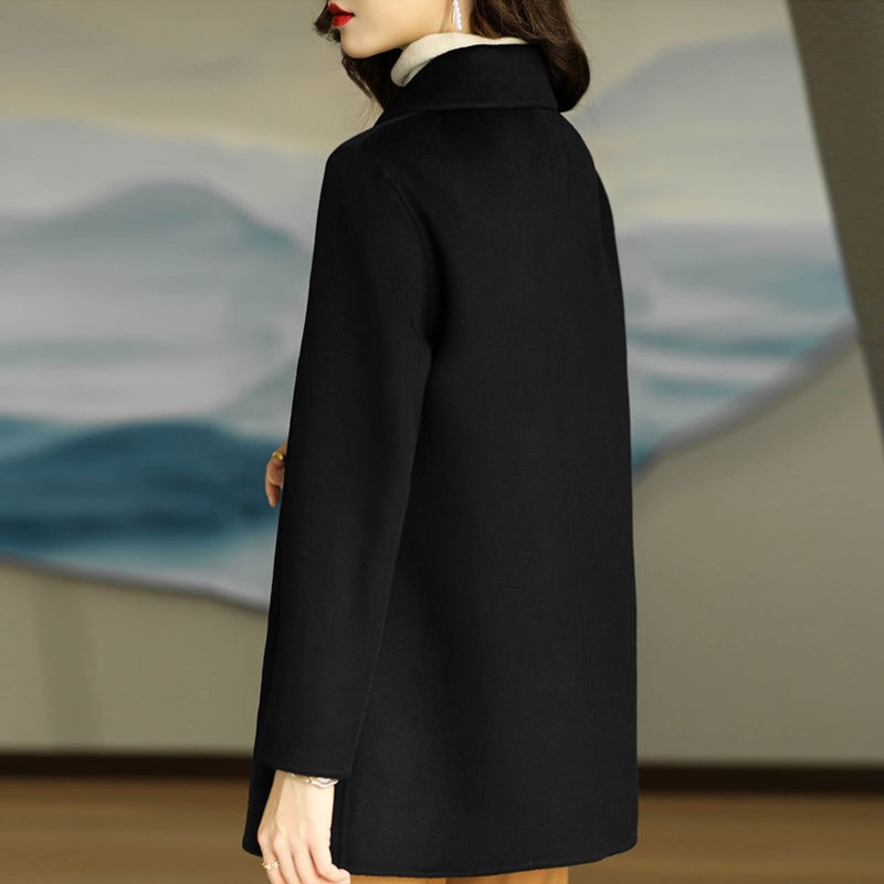 Person wearing a black coat with a blurred background